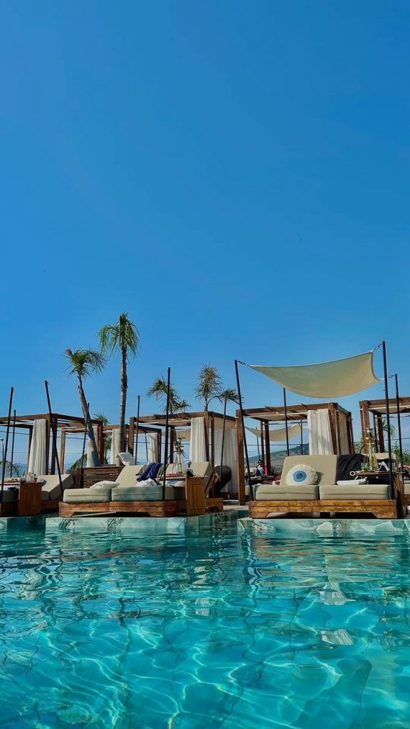 Sunbeds and overwater cabanas at Bianco Lounge Bar in Ksamil, Albania, offering panoramic views across the turquoise waters and the small Ksamil Islands.
