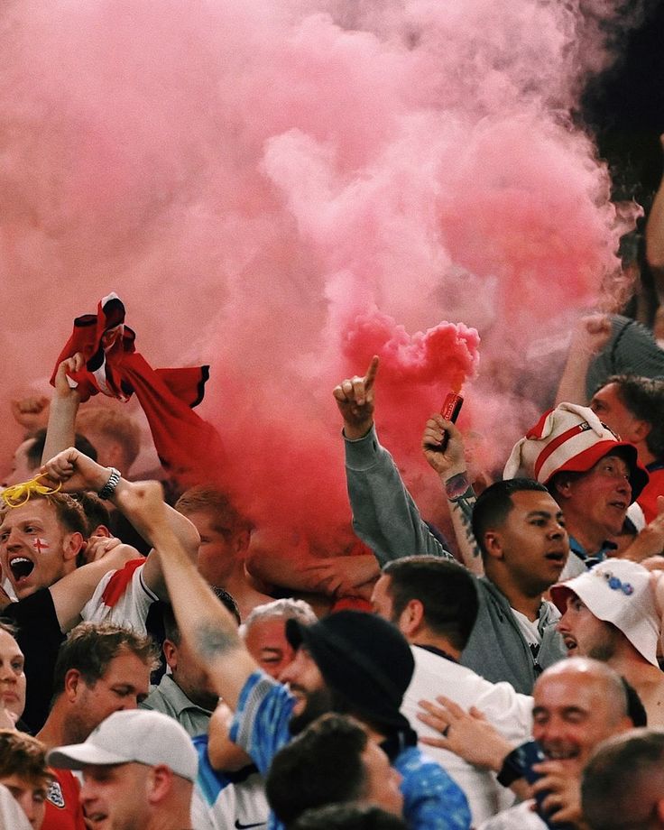 England football fans celebrating in the streets with red color flares.